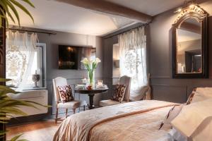 una camera da letto con un letto, un tavolo e delle sedie di The Lucca Palatial Suite a Lucca