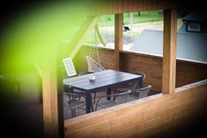 een houten tafel en stoelen op een veranda met een tafel bij Dla Dwojga in Solina