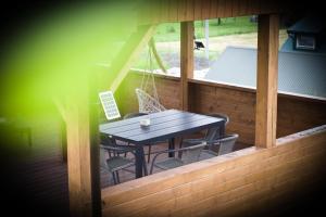 a wooden table and chairs on a porch with a table at Dla Dwojga in Solina