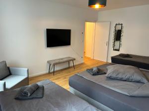 a bedroom with two beds and a tv and a chair at Reeperbahn Apartments in Hamburg