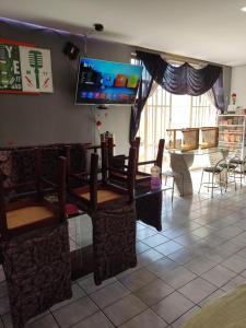 a dining room with a table and chairs and a tv at Parada 86 Hostel in Sao Paulo