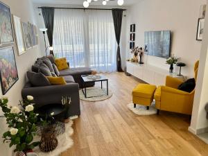 ein Wohnzimmer mit einem Sofa und gelben Stühlen in der Unterkunft Apartment Sweet Cherry in Split