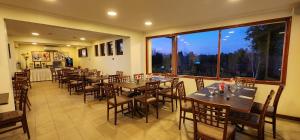 a restaurant with tables and chairs and a large window at Hotel y Cabañas Las Mellizas - Caja Los Andes in Los Ángeles