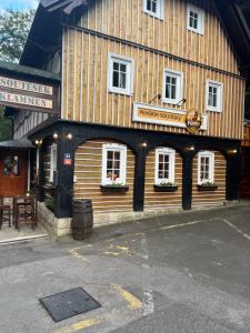 a large wooden building with a sign on it at Pension Soutěsky in Hřensko