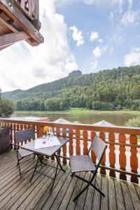 a table and chairs on a deck with a view of a river at Pension Bomätscher in Königstein an der Elbe