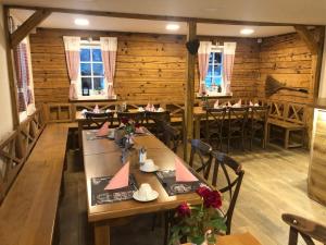 a restaurant with wooden walls and tables and chairs at Pension Soutěsky in Hřensko +52 photos