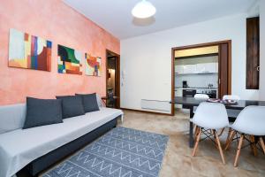 ガルニャーノにあるAppartamenti vista lago a Villa Paolinaのソファとテーブルと椅子のあるリビングルーム