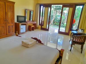 a bedroom with a bed and a tv in a room at Hotel rooms 2 minutes to Monkey Forest in Ubud