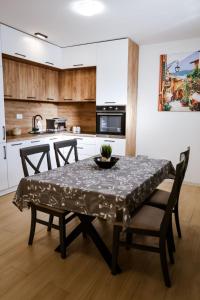 a dining room with a table and chairs in a kitchen at Apartment Neiv in Tivat