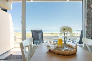 a dining room with a table with a view of the ocean at Bellevue-Haus-B-Wohnung-13 in Großenbrode