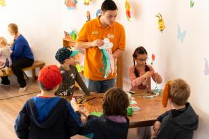 a man standing in front of a table with children at Dormio Resort Eifeler Tor in Heimbach