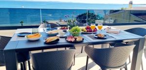 a blue table with food and drinks on a balcony at Dinary Penthouse apartment in Vir