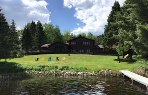 a house on a hill next to a body of water at Peace Of Mind On Namakagon Condo in Namekagon