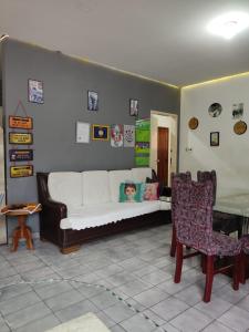 a living room with a white couch and a chair at Parada 86 Hostel in Sao Paulo