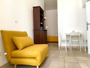 un soggiorno con divano giallo e tavolo di Dimora Zia Giovanna - Puglia Mia Apartments a Monopoli