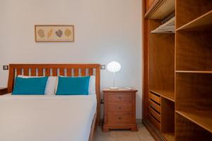 um quarto com uma cama com almofadas azuis e uma cómoda em Sabbia Suites Sea View La Playita em Puerto del Carmen