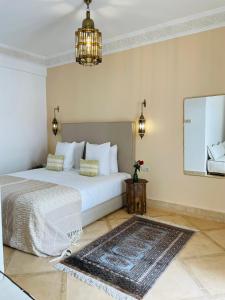 a bedroom with a white bed and a rug at Riad Deha & Spa in Marrakech
