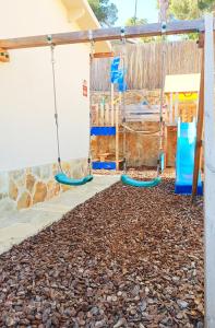 un parque infantil con columpios y rocas en House with pool near Park Guell en Barcelona