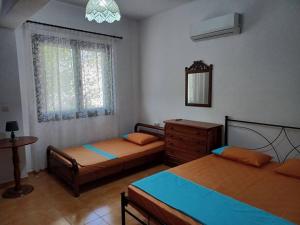 een slaapkamer met 2 bedden, een dressoir en een raam bij Skyros BnB, Calliope in Molos in Skiros