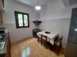 Skyros BnB, Calliope in Molos في سكيروس: مطبخ مع طاولة مع كراسي ونافذة