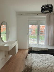 プリシュティナにあるPrestige Apartmentsのベッドルーム1室(ベッド2台、洗面化粧台、鏡付)