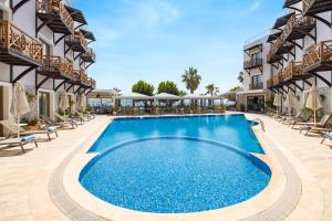 a pool at a resort with chairs and umbrellas at Elite Hotel Yalıkavak, Bodrum in Yalıkavak