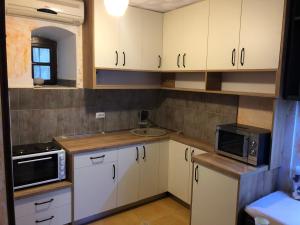 a kitchen with white cabinets and a sink and a microwave at Seaside dream in Trstenik