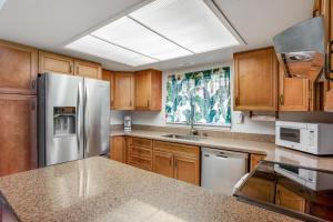 a kitchen with wooden cabinets and a stainless steel refrigerator at Princeville Puamana 21A in Princeville