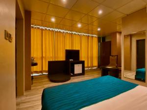 a bedroom with a bed and a tv in it at Ace Prime Hotel in Greater Noida