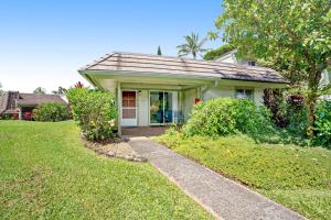 a small white house with a pathway leading to the front door at Princeville Puamana 21A in Princeville