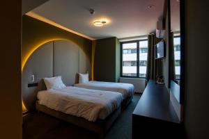 a hotel room with two beds and a window at Green Hotel in Genk