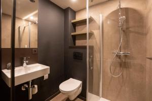 een badkamer met een douche, een toilet en een wastafel bij Green Hotel in Genk