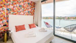 1 dormitorio con cama blanca y ventana grande en Welcomely - Affittacamere Seamphony Rooms, en Olbia