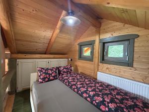 a bed in the corner of a room in a cabin at Căsuța din pădure in Piatra Neamţ