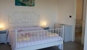ein weißes Kinderbett in einem Schlafzimmer mit zwei Nachttischen in der Unterkunft Il Riccio Volante in Ortona