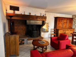 ChauzonにあるChambres d'hôtes les Clapasのリビングルーム(暖炉、赤いソファ付)