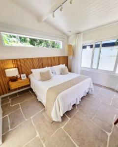 a bedroom with a large bed and a window at Abracadabra Pousada in Búzios