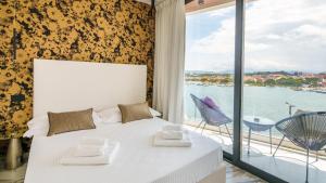 een slaapkamer met een bed en uitzicht op het water bij Welcomely - Affittacamere Seamphony Rooms in Olbia