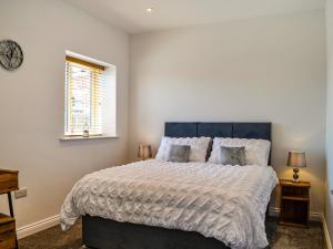 a bedroom with a large bed and a window at Fell View Cottage - Uk43378 in Kirklinton