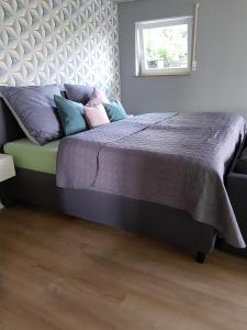 Un dormitorio con una cama con sábanas y almohadas púrpuras. en Ferienwohnung Frieda en Frickingen