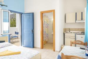 a room with a blue door and a kitchen at Studios Ninemia Serifos 2 in Livadi