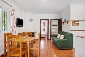 ein Wohnzimmer mit einem Tisch und einem grünen Sofa in der Unterkunft Casa Paqui 1 in Roche