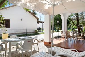 patio con tavolo, sedie e ombrellone di Casa Paqui 1 a Roche