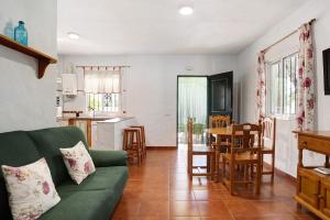ロッシェにあるCasa Paqui 1のリビングルーム(緑のソファ付)、キッチンが備わります。