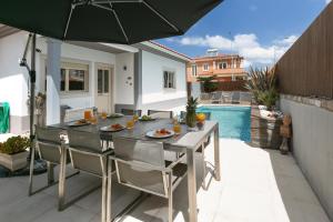 a patio with a table and chairs and an umbrella at Óbidos Pool & Charm in Óbidos