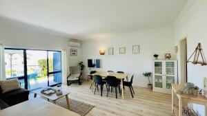 a living room and dining room with a table and chairs at Jardim da Oura by Check-in Portugal in Albufeira