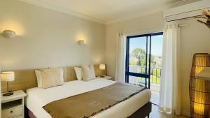 a bedroom with a bed and a large window at Jardim da Oura by Check-in Portugal in Albufeira +15 photos