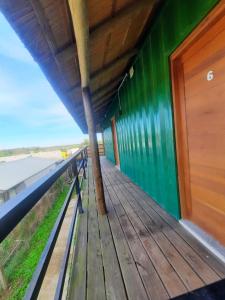 - une terrasse en bois sur un bâtiment avec vue sur l'eau dans l'établissement Posada El Mariscal, à Paso de los Toros