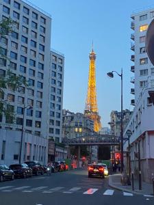 a view of the eiffel tower from a street with cars at Studio agréable proche Tour Eiffel in Paris