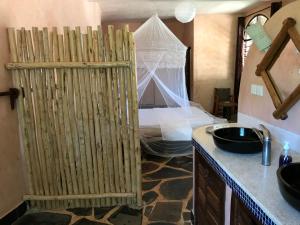 Habitación con baño con cama y puerta de madera. en Wagawimbi Villa 560 m2, Breathtaking View of the Indian Ocean, Kenya, en Shimoni